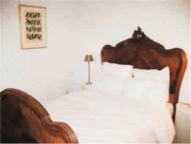 Old french wooden bed with white linen.